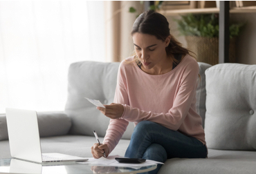 woman with a laptop and receipts reconciling statements