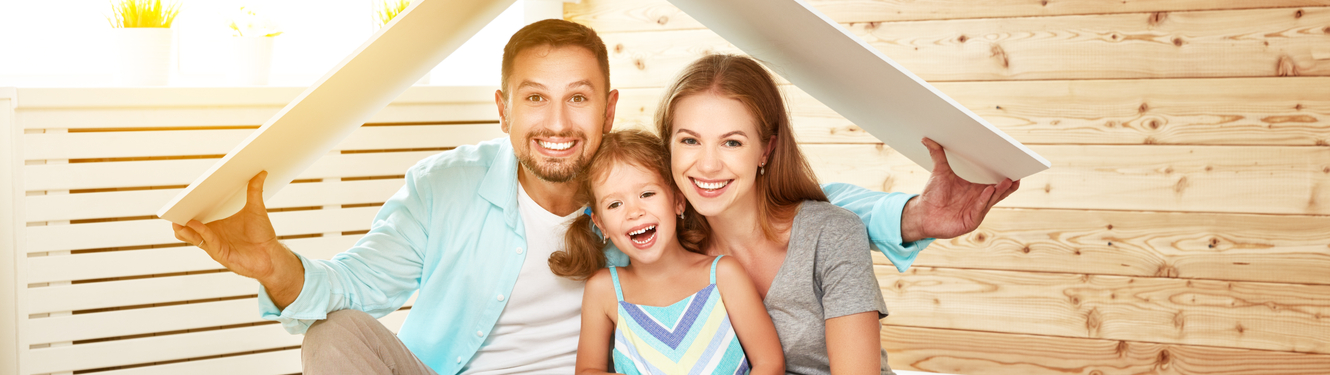 Mom, dad and daughter playing under cardboard box