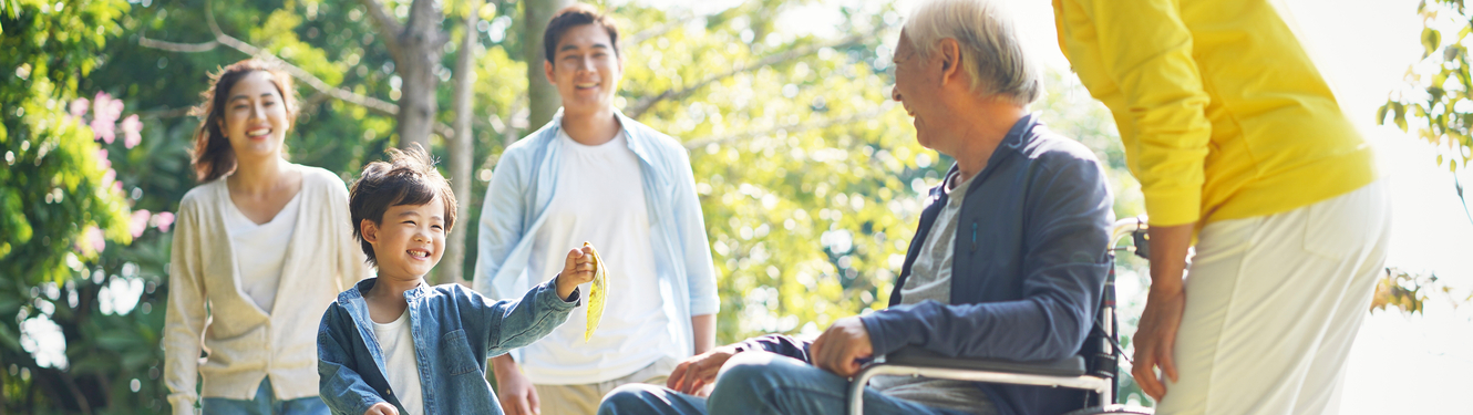 Disabled Asian man with grandchildren at the park